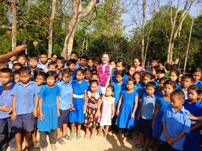 Danish Ambassador to Bangladesh Ms. Hanne Fugl Eskjær stands with children at a Rangamati school. She visited the school and many other places in Rangamati in 2014 to see first-hand the progress of DANIDA-funded HYSAWA project